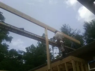 Carpenter setting a ridge beam over a new addition frame — Ice Dam Removal by Roofing Brothers in Haverstraw