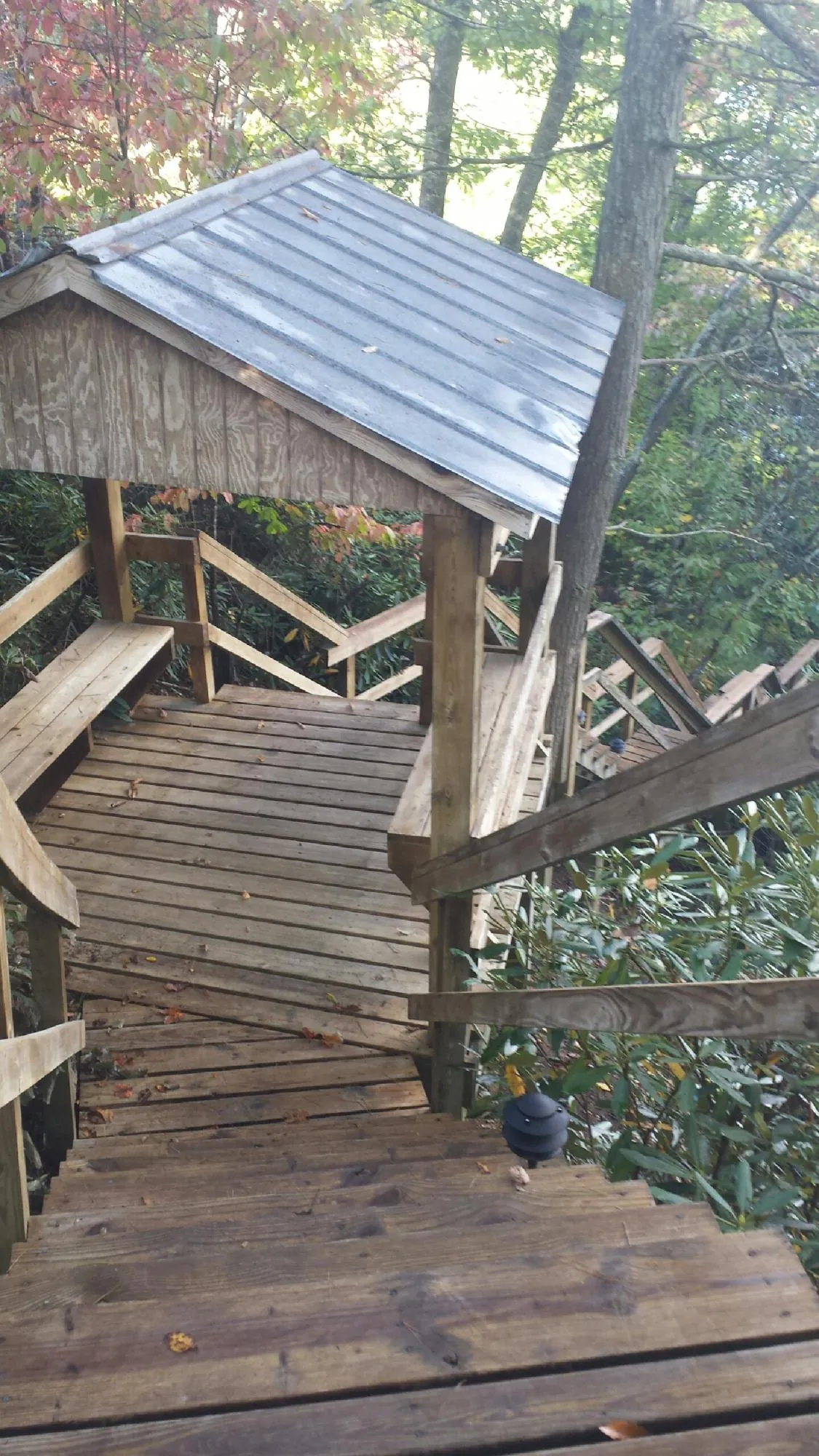 Metal roofed shelter over wooden steps on a wooded walkway — Skylight Repair & Installation work by our crew in Haverstraw
